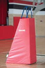 Volleyball freestanding referee platform with a red, one piece protective pad in a gym.