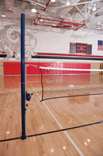 Slide multi-sport system set at badminton height in a gym with red wall padding.